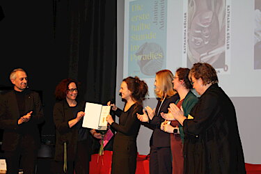 Katharina Köller erhält auf der Bühne die Urkunde zum Puchheimer Buchpreis.